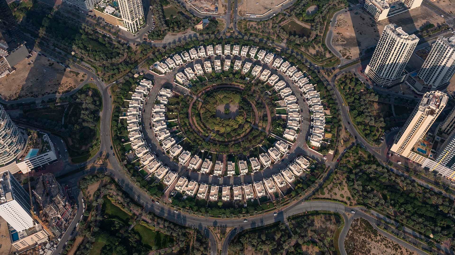 Landscaped park, palm trees and homes in Jumeirah Village Circle
